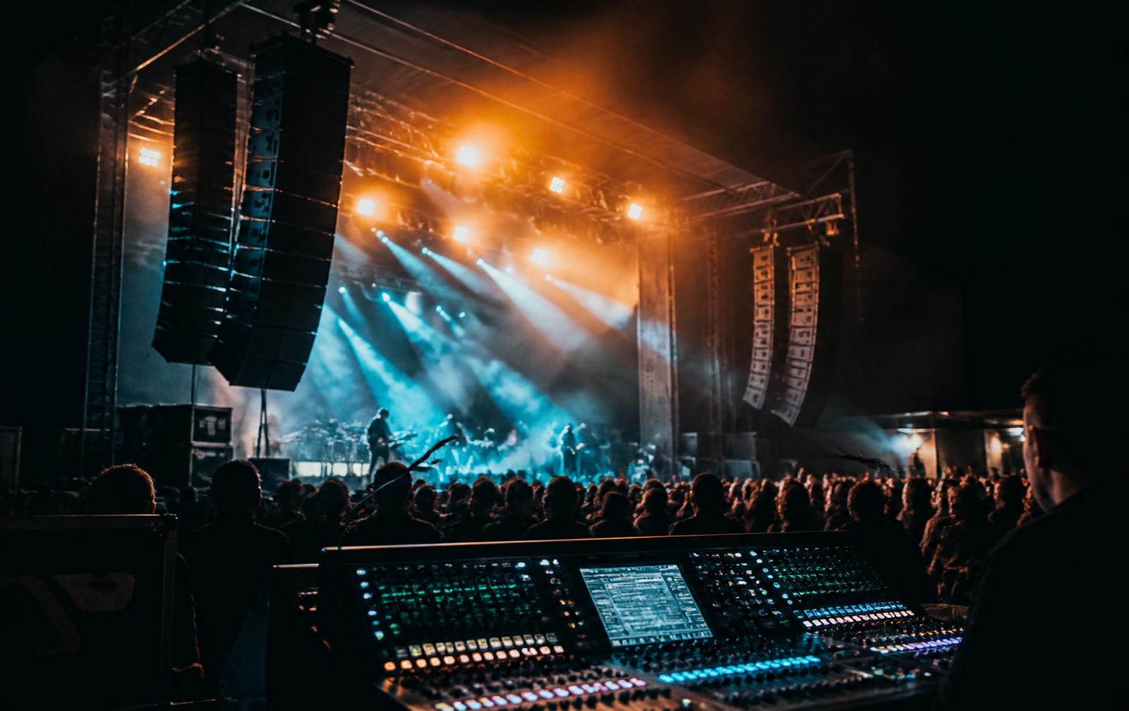 Professional event sound setup with line-array speakers and a mixing console